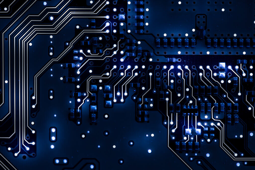 Dalton, Georgia (DNN1-2) A detailed close-up of a circuit board, with glowing components and intricate pathways illuminated in blue, representing technological complexity.