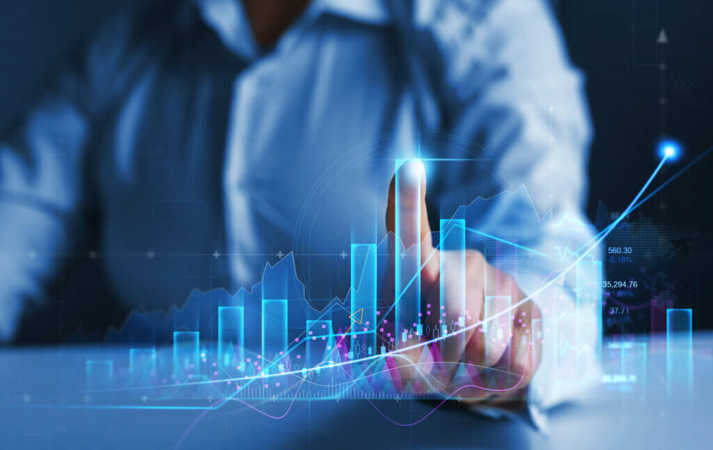 Financial Services A business professional interacting with digital graphs and data, touching a virtual touchscreen to manipulate financial and market data visualizations.