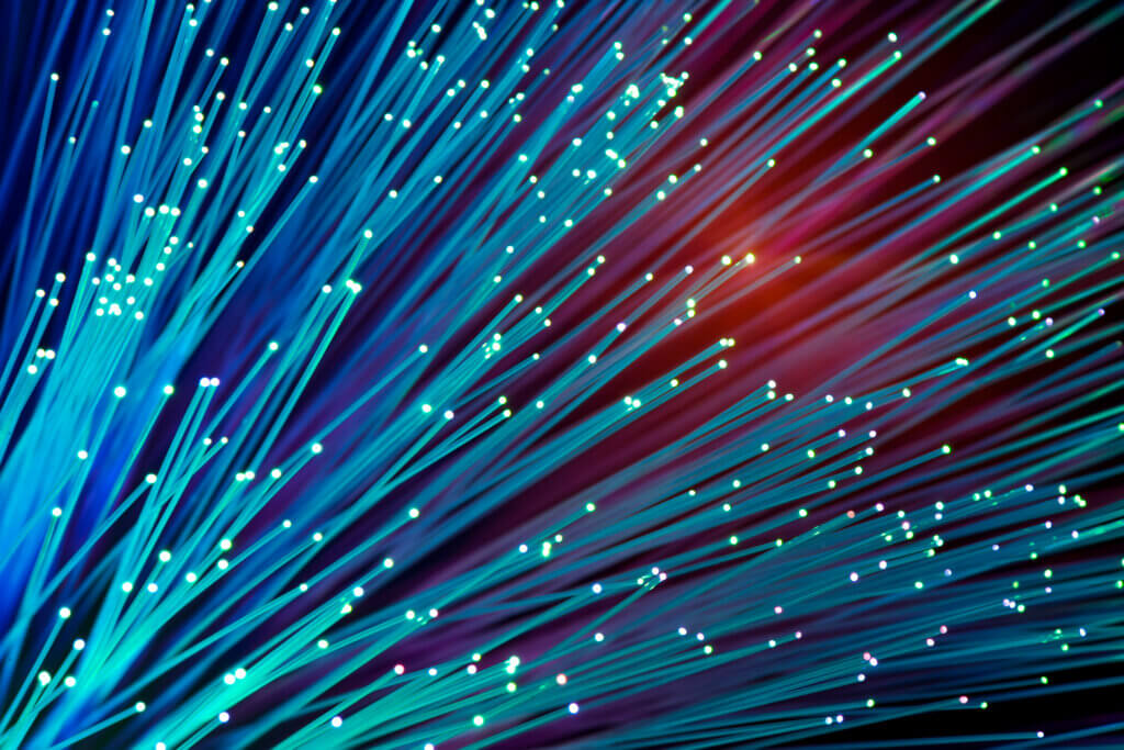 Media & Entertainment 1 Close-up of colorful fiber optic cables emitting light in dark background.